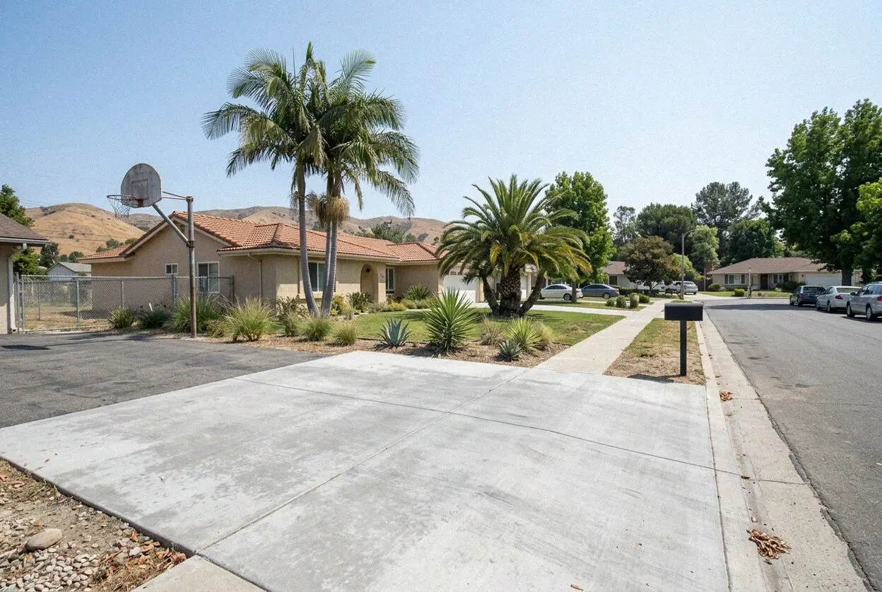 A new concrete patio and area drain behind a hillside house in Brea, CA